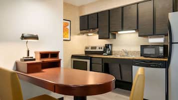 A modern kitchen with dark cabinets, a microwave, a coffee maker, and a dishwasher.