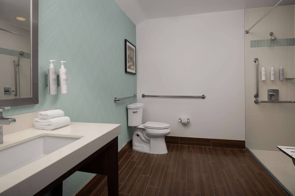 A modern bathroom with a sink, toilet, and shower area.