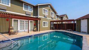 A residential pool area with a clear blue pool, a pergola, and a covered patio area. - Best Western Plus The Inn at Horse Heaven (Prosser)