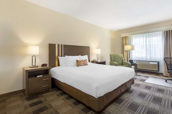 A hotel room with a large bed, two bedside tables with lamps, a chair, and a window with curtains. - Best Western Plus The Inn at Horse Heaven (Prosser)