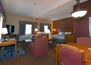 A hotel room with a bed, a sofa, a desk with a computer, a TV, and a ceiling light. - Best Western Plus The Inn at Horse Heaven (Prosser)