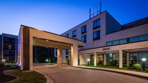 Ein modernes Gebäude mit überdachter Eingangspartie, großen Fenstern und einem gut sichtbaren Adressschild.