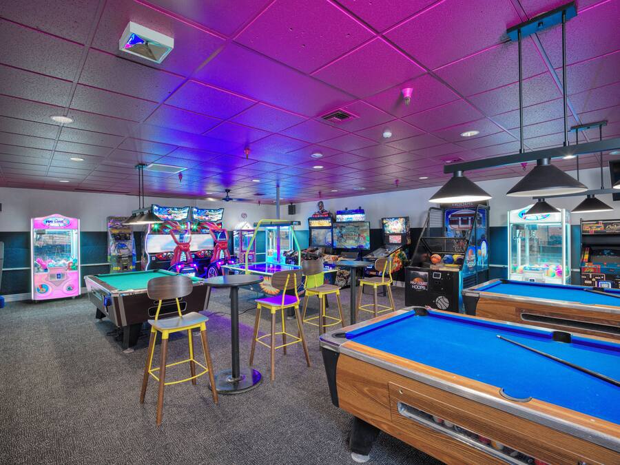 A recreational area with pool tables, arcade games, and seating.