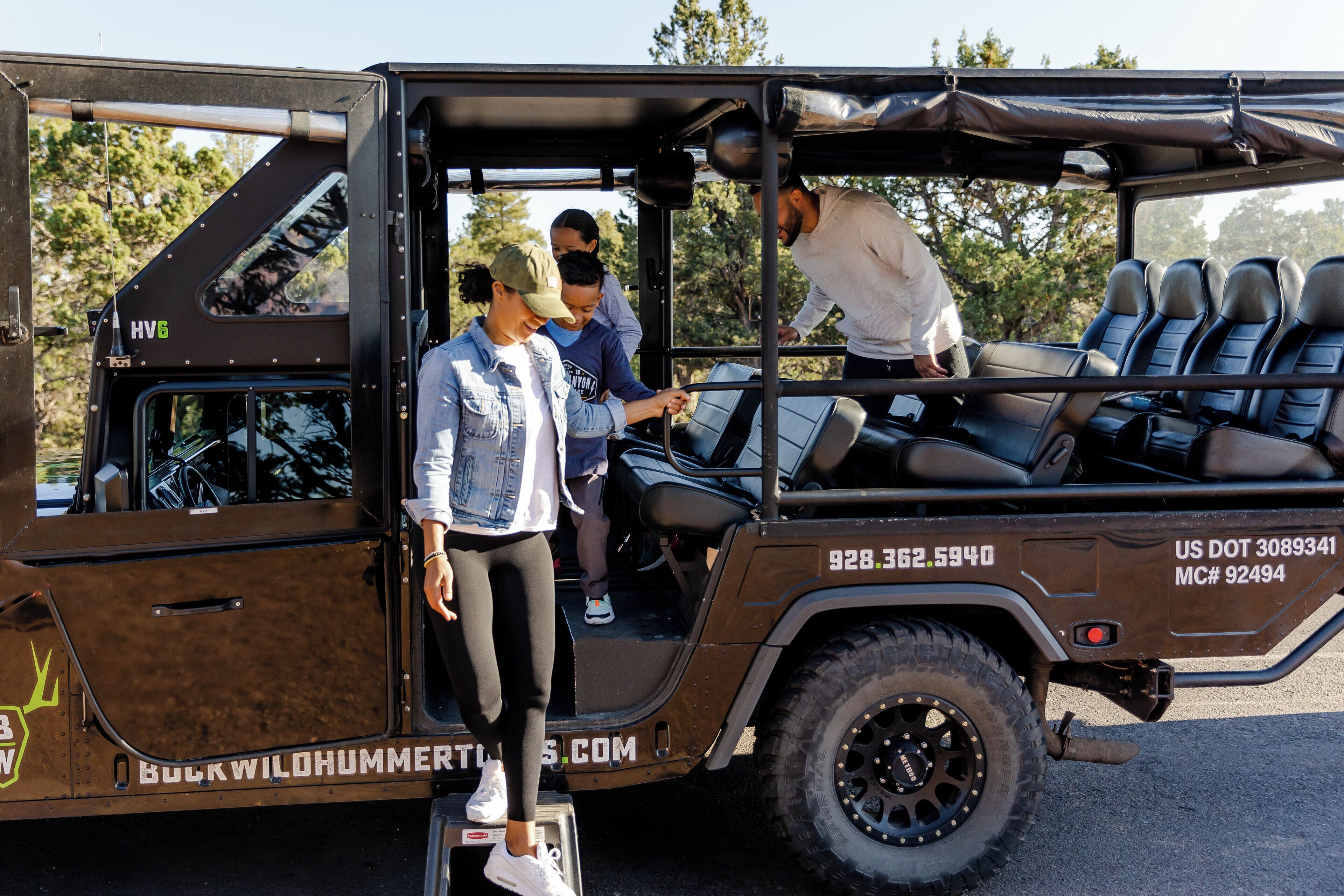 A brown off-road vehicle with a roof, seating for multiple passengers, and a visible license plate.