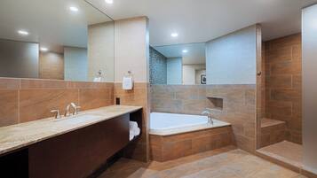 Ein modernes Badezimmer mit einem Waschtisch mit zwei Waschbecken, einer freistehenden Badewanne und einer begehbaren Dusche.