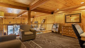 A wooden interior with a sofa, a chair, a wooden cabinet, and a mirror. - Best Western Plus Olympic Inn (Klamath Falls)