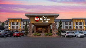 A Best Western Plus hotel with a modern facade, a parking lot, and a clear sky. - Best Western Plus Olympic Inn (Klamath Falls)