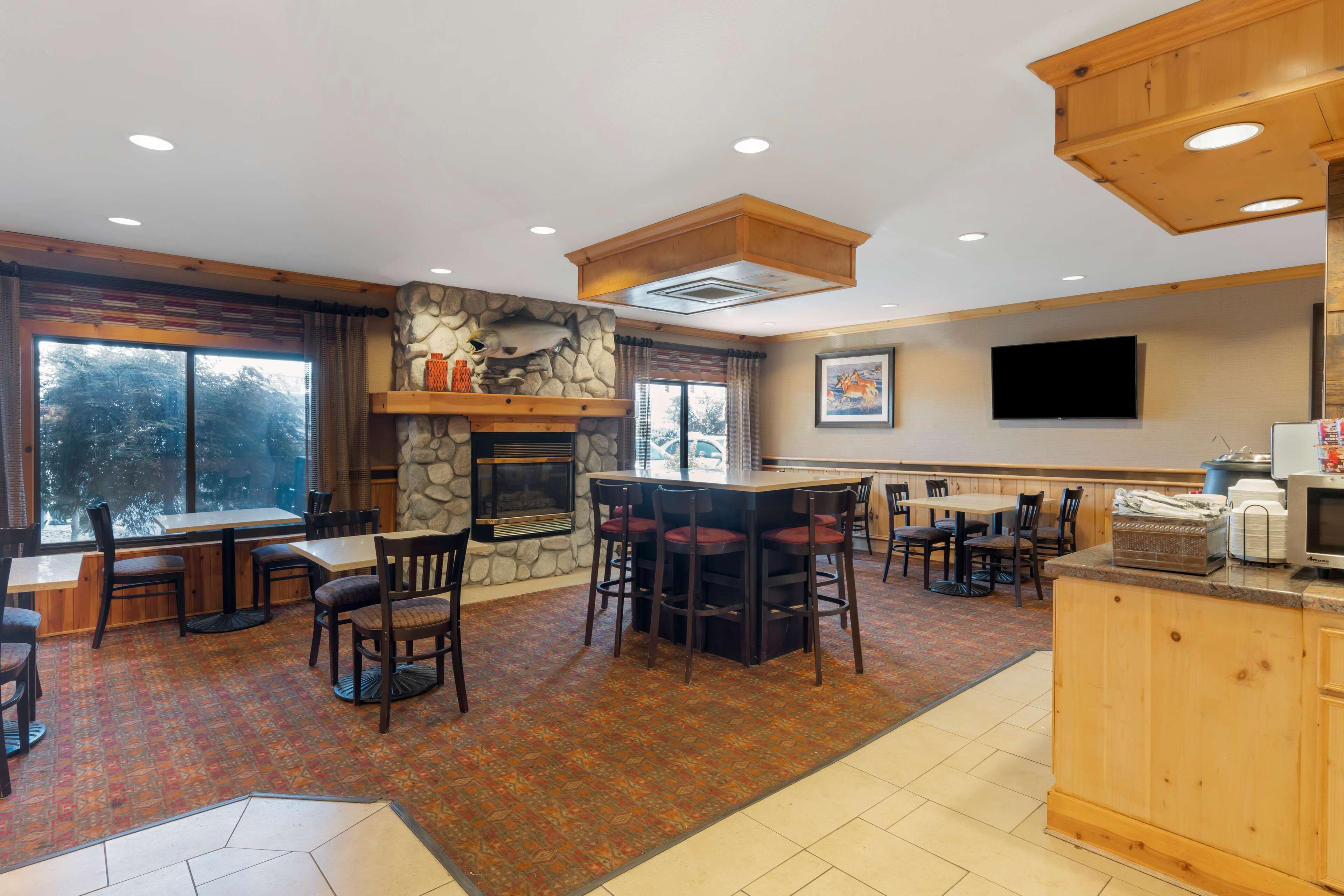 A restaurant with a stone fireplace, wooden bar, and outdoor seating.