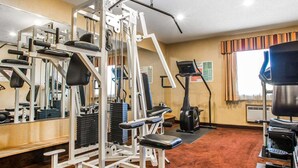 Ett gym med olika typer av träningsredskap, ett löpband och en motionscykel.