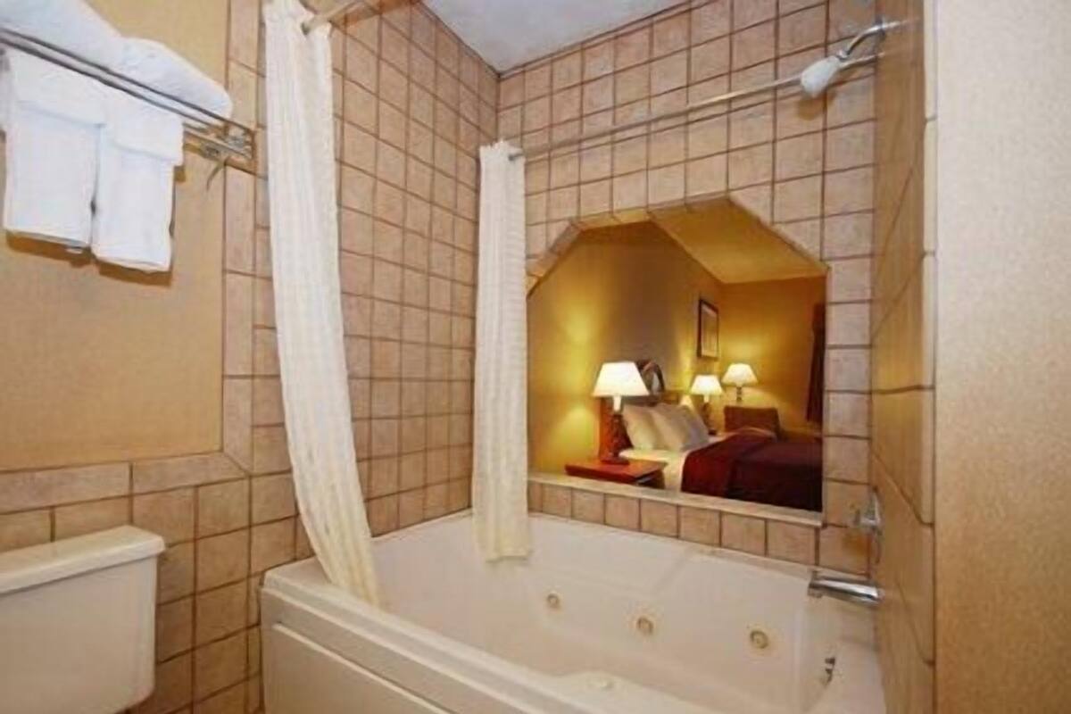 Un baño con bañera, inodoro y zona de ducha.