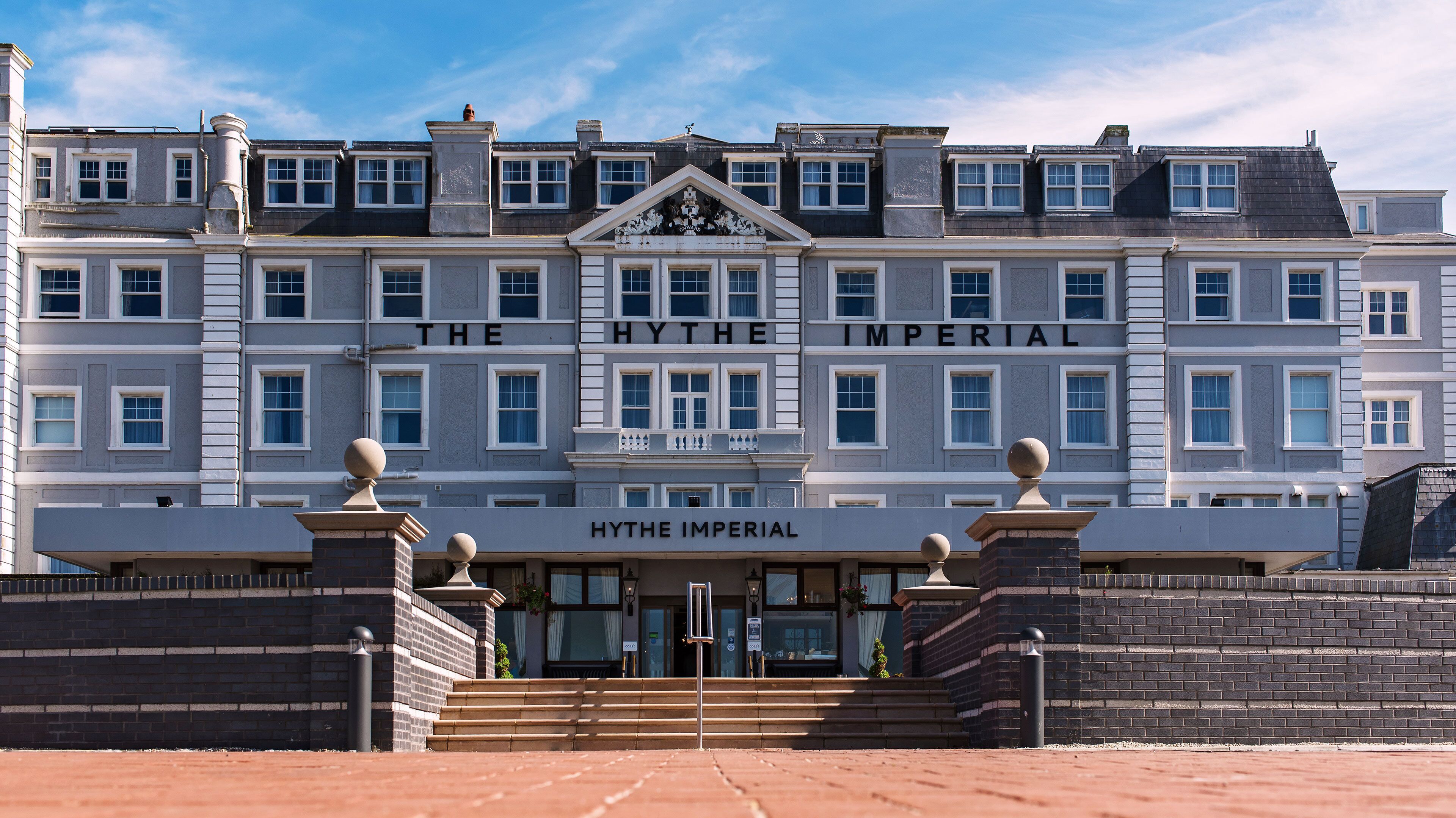 Un edificio grande de varios pisos con una entrada destacada y el nombre "The Hythe Imperial" exhibido arriba.