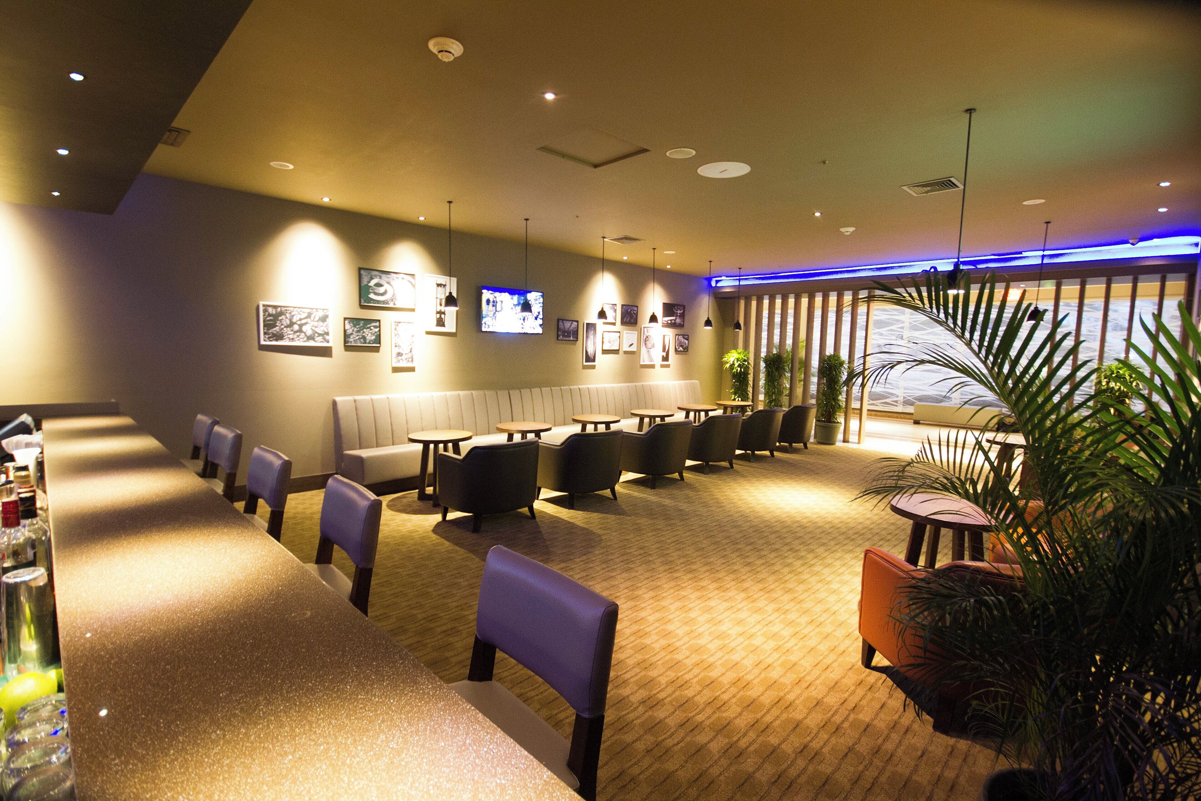 A hotel lobby with seating areas, a television, and a reception desk.