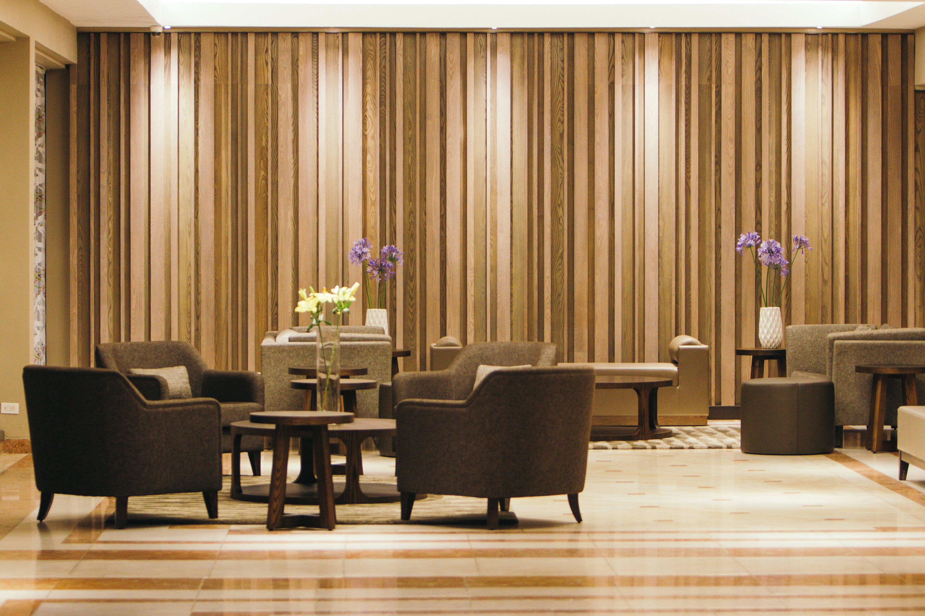 Eine Hotelhalle mit Sitzgelegenheit, einer Rezeption und einer großen Wandpaneelausstattung aus Holz.