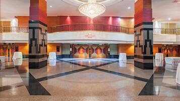 A spacious lobby with a central open area, a chandelier, and a sign for Crown Plaza Manila.