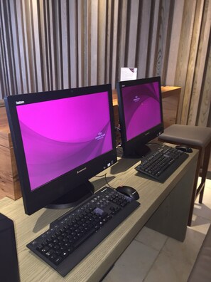 Dos monitores Lenovo sobre un escritorio de madera, con un teclado y un ratón.