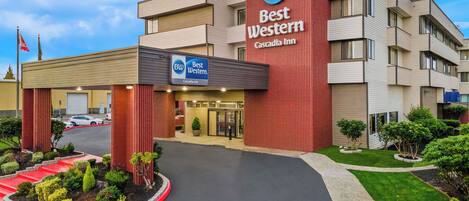 A Best Western hotel with a modern design, featuring a prominent red facade and a clear entrance with directional arrows on the ground.