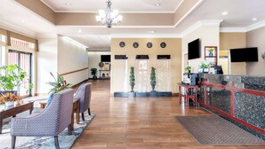 A hotel lobby with a reception desk, seating area with chairs, a chandelier, and a wooden floor. - Best Western Cascadia Inn (Everett)