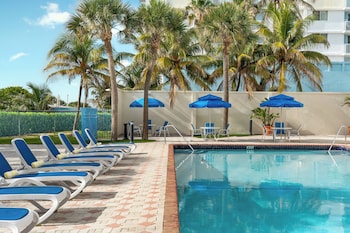 Outdoor pool, open 8:00 AM to 8:00 PM, pool umbrellas, sun loungers at Crystal Beach Suites Miami Oceanfront Hotel