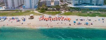 På stranden, vit sandstrand, solstolar och strandhanddukar