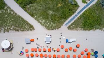 Aan het strand, wit zand, ligstoelen aan het strand, strandlakens