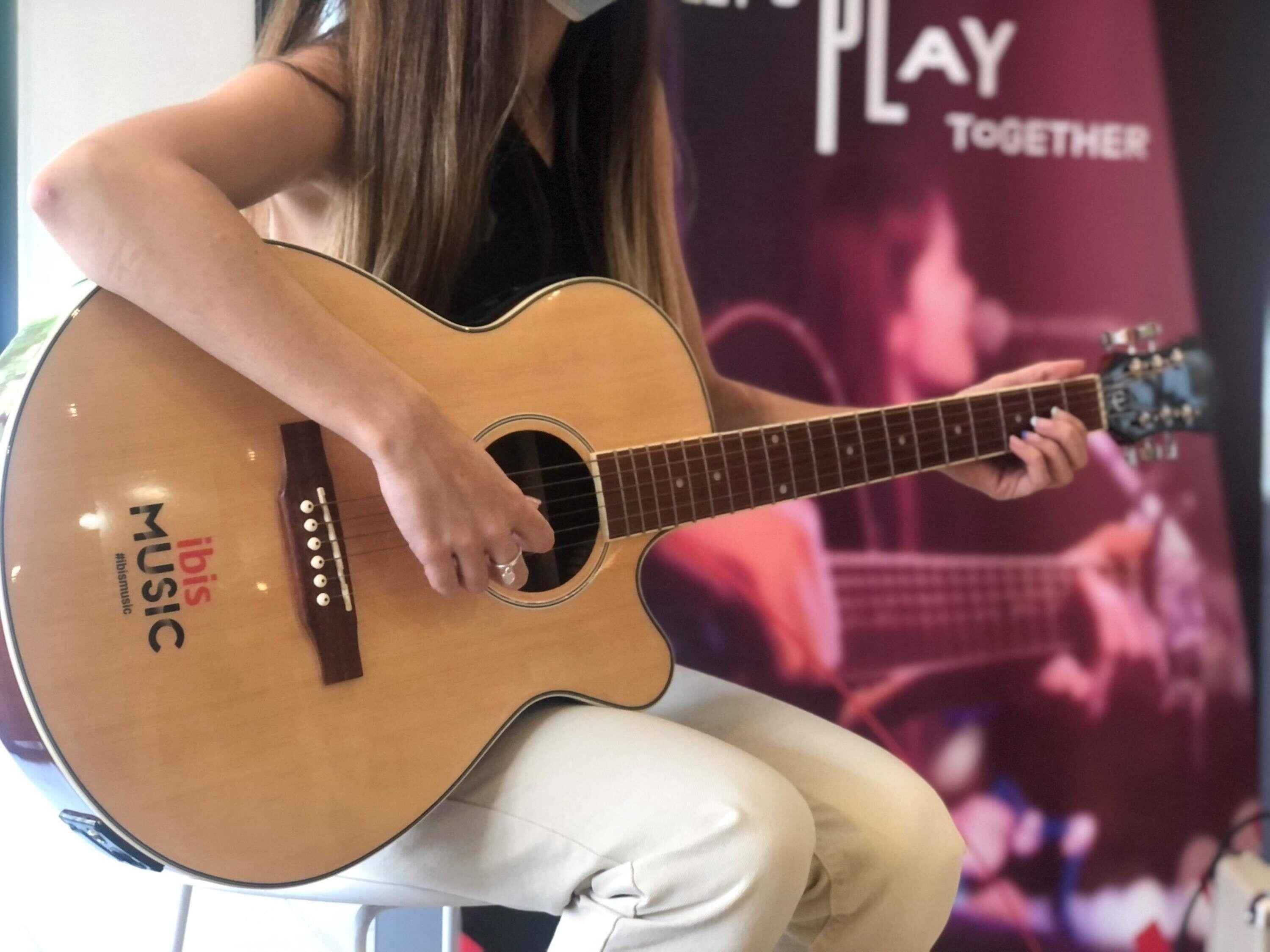 A person playing an acoustic guitar.