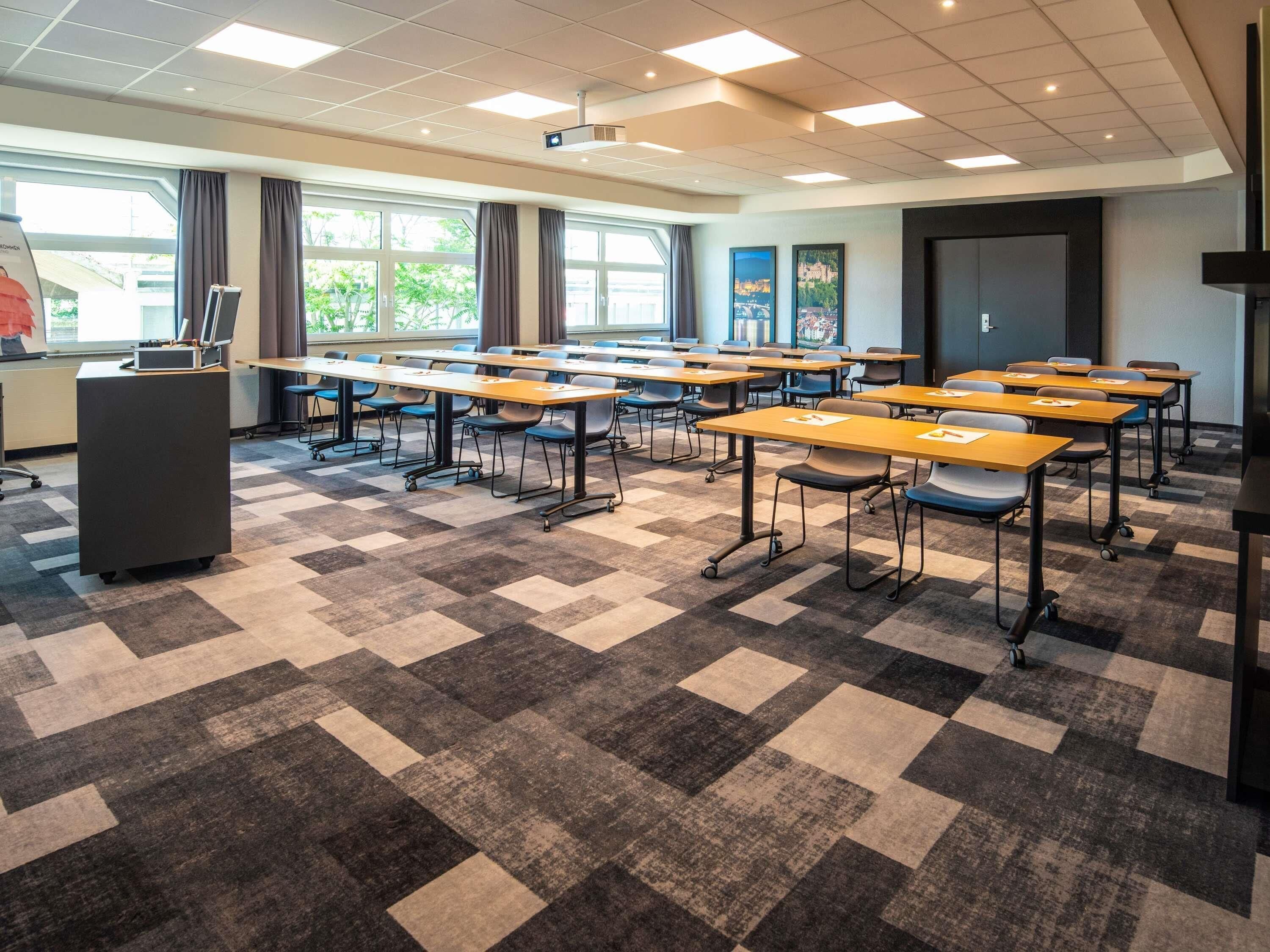 A classroom with desks, chairs, a podium, and a projector.