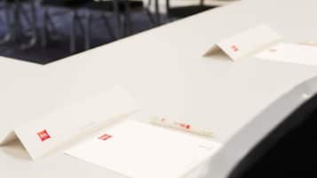 Ein Konferenztisch mit Unterlagen und einem Stift, der eine geschäftliche oder Besprechungssituation andeutet.