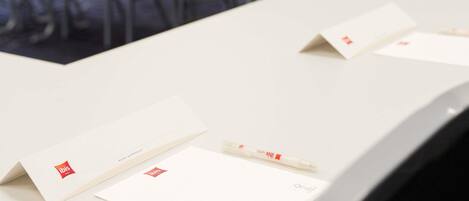 Una mesa de conferencias con documentos y un bolígrafo, que sugiere un ambiente de negocios o una reunión.