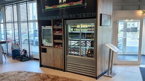 A reception area with a chalkboard sign, a reception desk, and a refrigerated display case. - ibis Heidelberg Hauptbahnhof (Heidelberg)