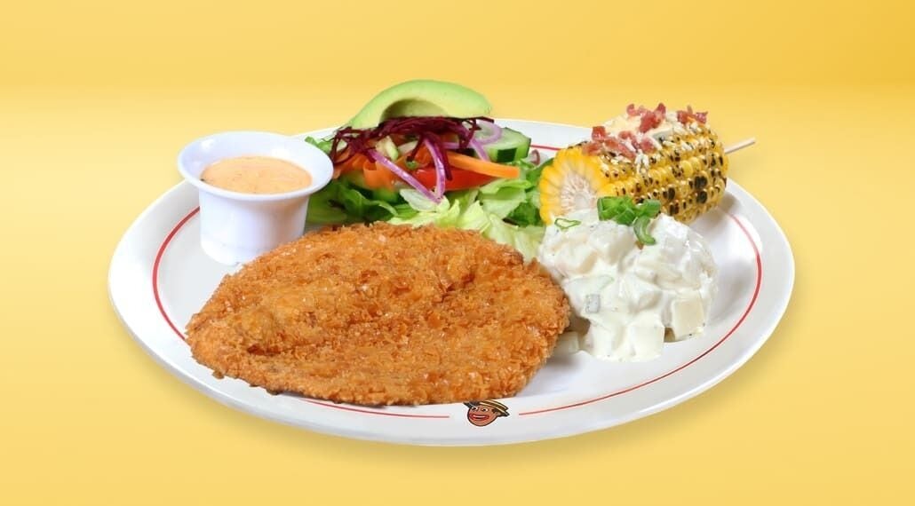 A plate with a breaded cutlet, a salad, a corn on the cob, and a small bowl of sauce.