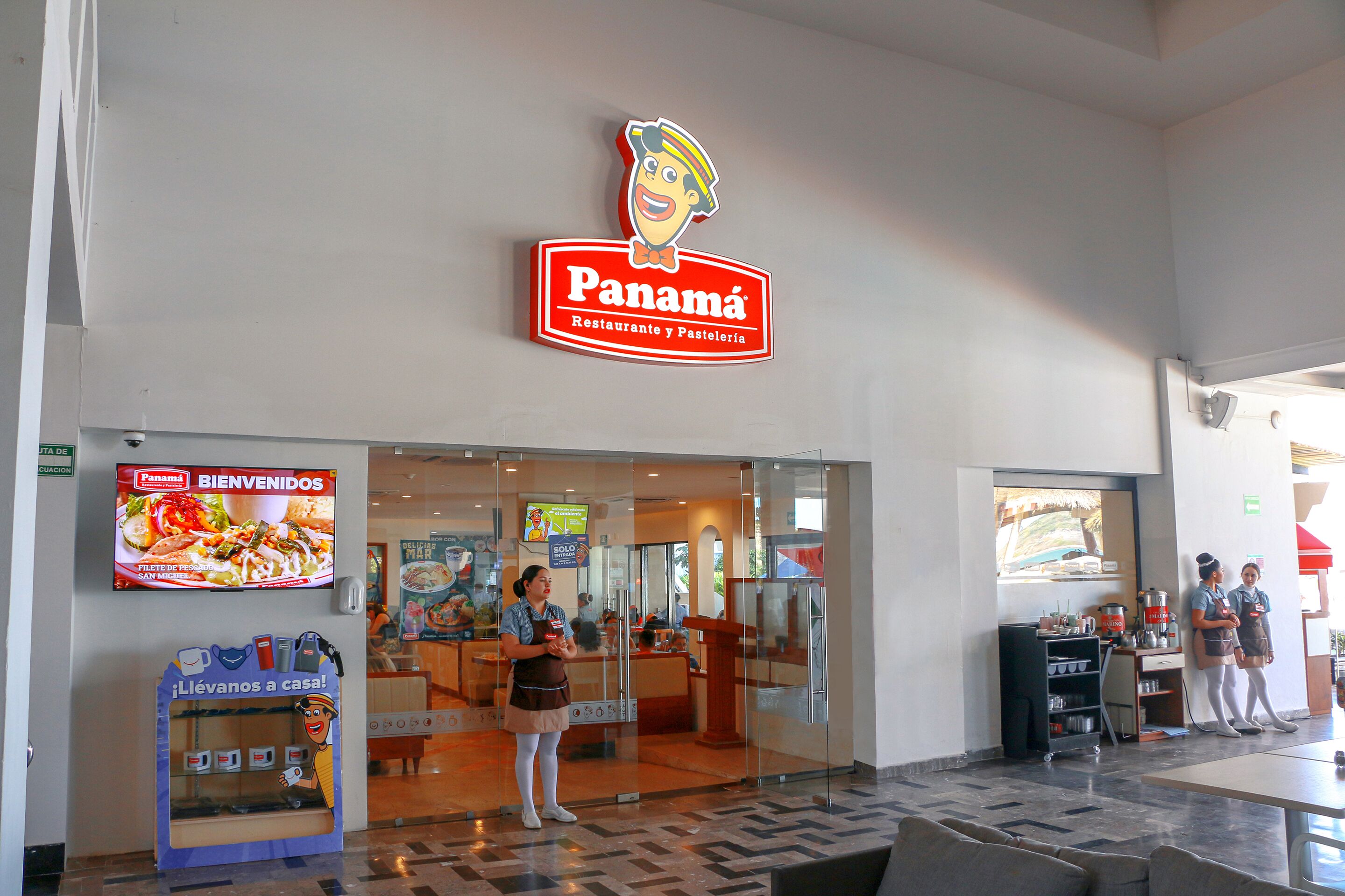 Un restaurant à Panama, reconnaissable à son grand panneau, à son menu affiché sur un écran numérique et à un distributeur automatique de café situé à l’extérieur.