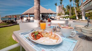 A breakfast table with a plate of food, a cup of coffee, and a menu.