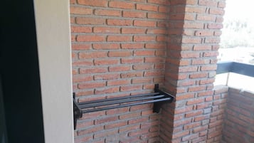 Un coin d'un mur en briques avec un porte-serviettes en métal.