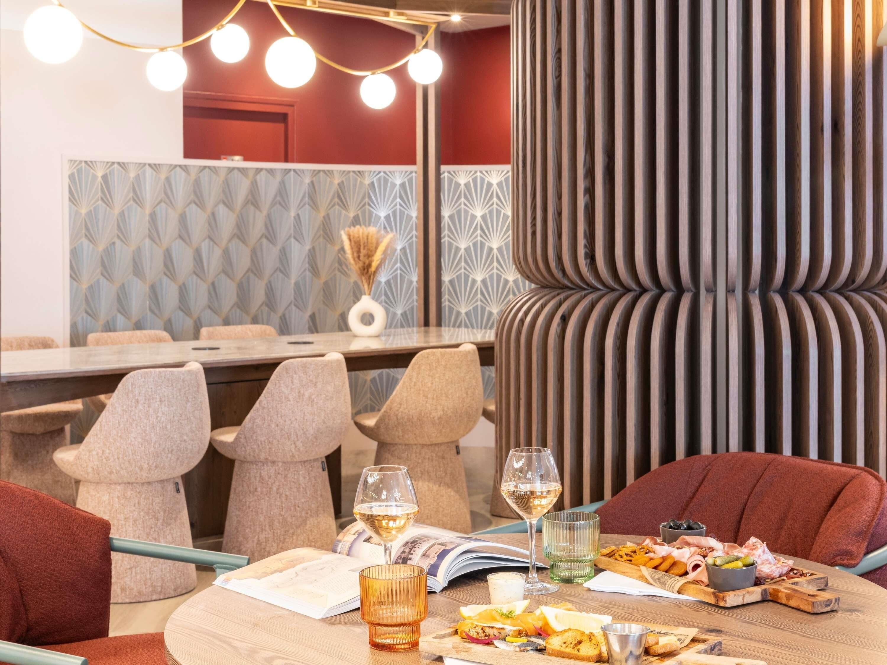 A dining area with a round table, chairs, a wine glass, and a menu.
