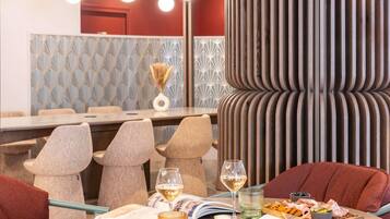 A dining area with a round table, chairs, a wine glass, and a menu.