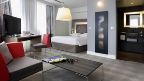 A modern hotel room with a bed, desk, and seating area. - Novotel Marseille Centre Prado Vélodrome (Marseille)