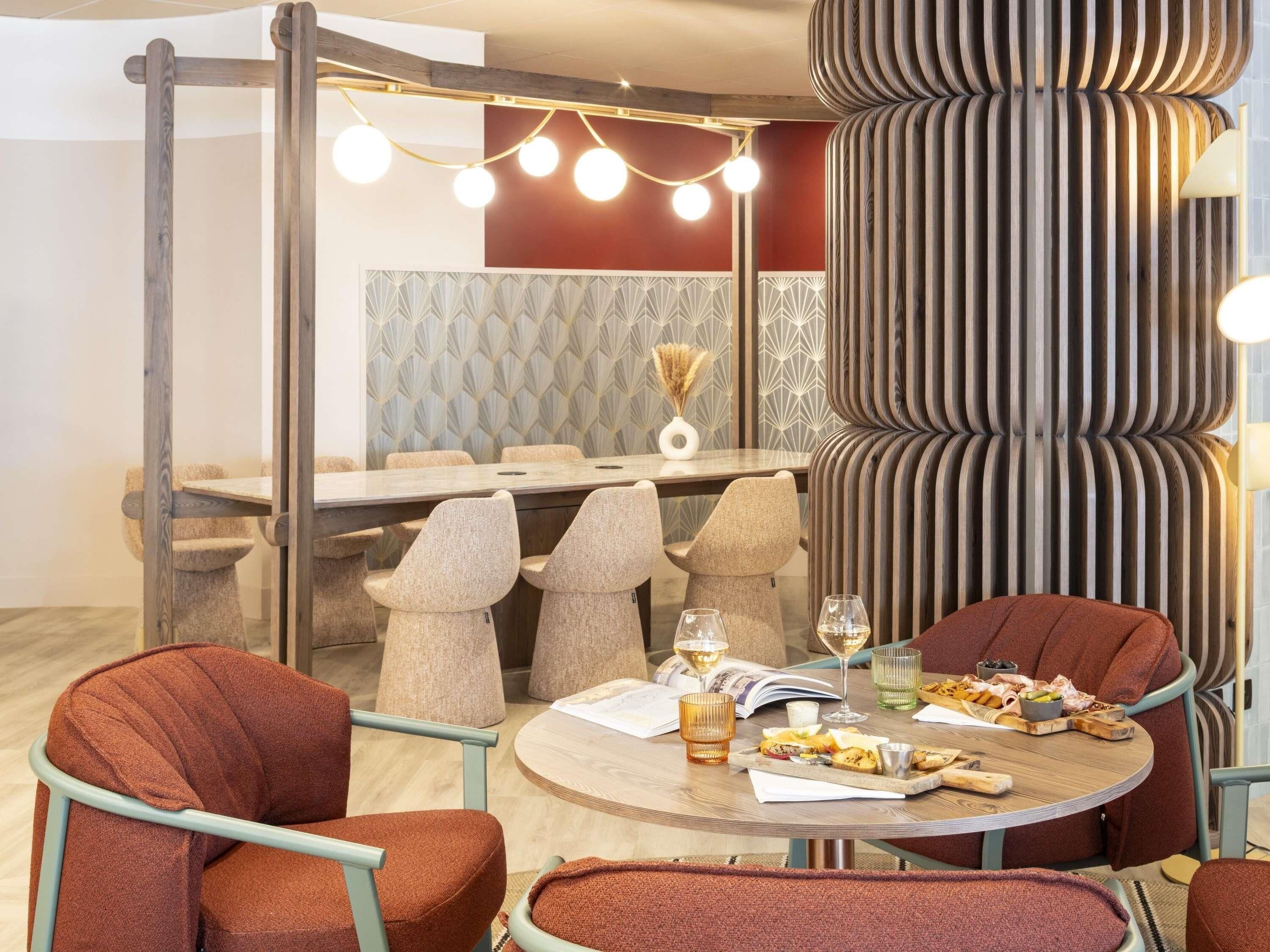 A dining area with a round table, multiple chairs, and a decorative column.