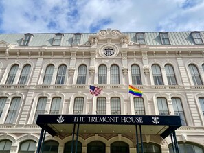 The Tremont House with a classical facade, multiple windows, and two flags (American and rainbow) on the building. - The Tremont House, Galveston, a Tribute Portfolio Hotel (Galveston)