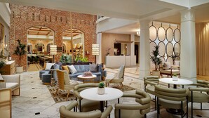Eine großzügige Lobby mit Backsteinwand, bequemen Sitzgelegenheiten und modernem Design.