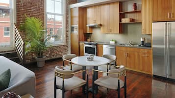Una cocina moderna con armarios de madera, un refrigerador de acero inoxidable y una mesa de comedor redonda con sillas.