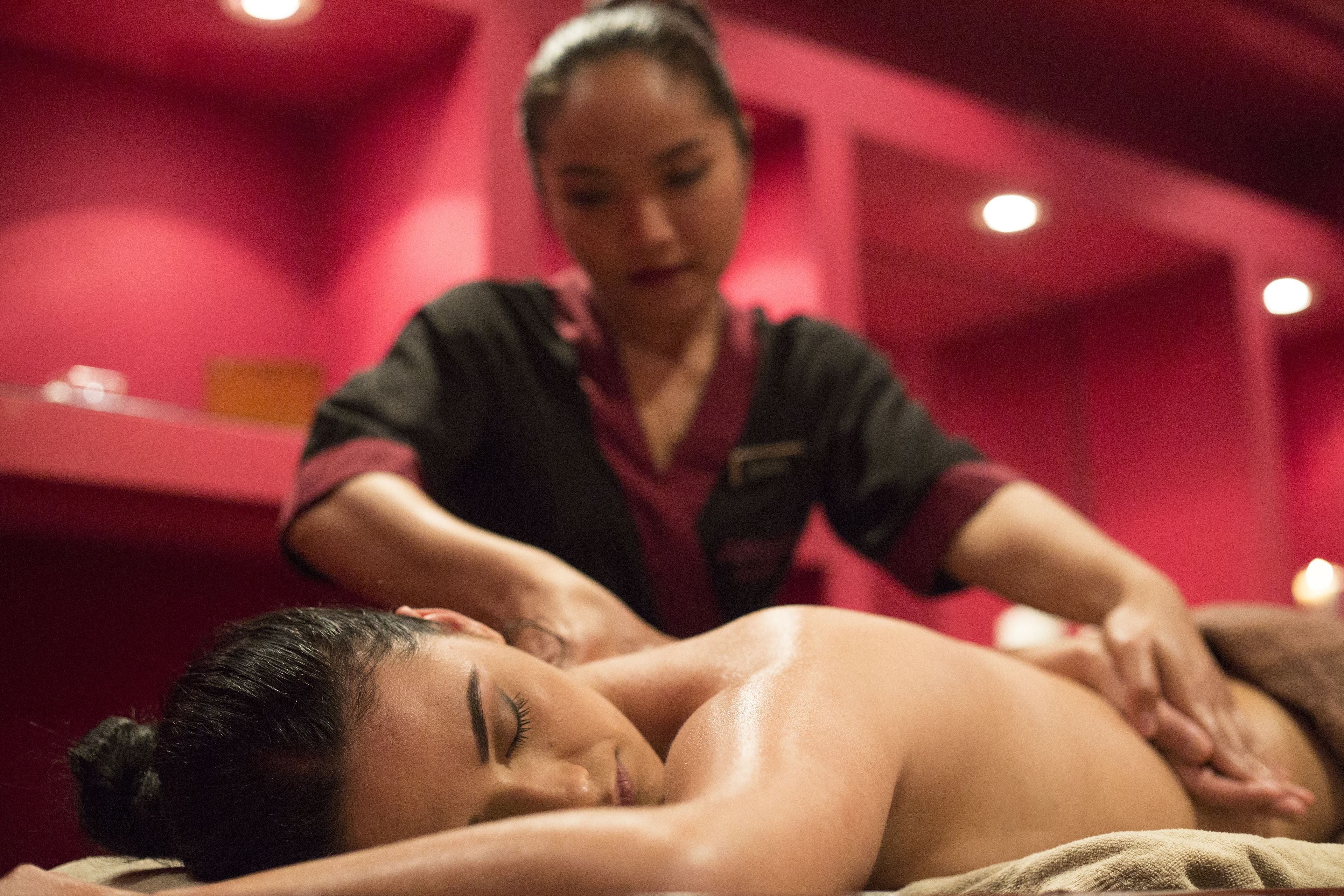 Eine Massageanwendung in einem Spa mit roter Einrichtung.