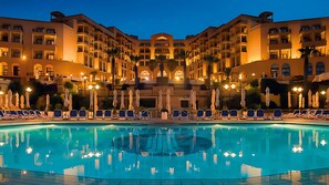 Relax by the pool surrounded by lounge chairs and umbrellas, or enjoy the hotel's symmetrical design from a balcony.