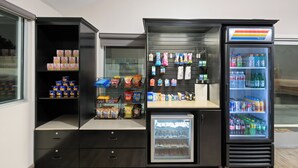 Ein Getränkeautomat mit Snacks, Erfrischungen, einer Kühlvitrine und einer Auswahl an Wasser und Limonade.