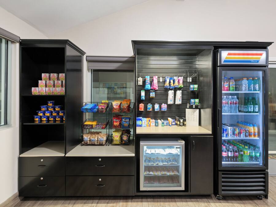 A vending machine with snacks and drinks, a refrigerated section, and a display of bottled water and soda.