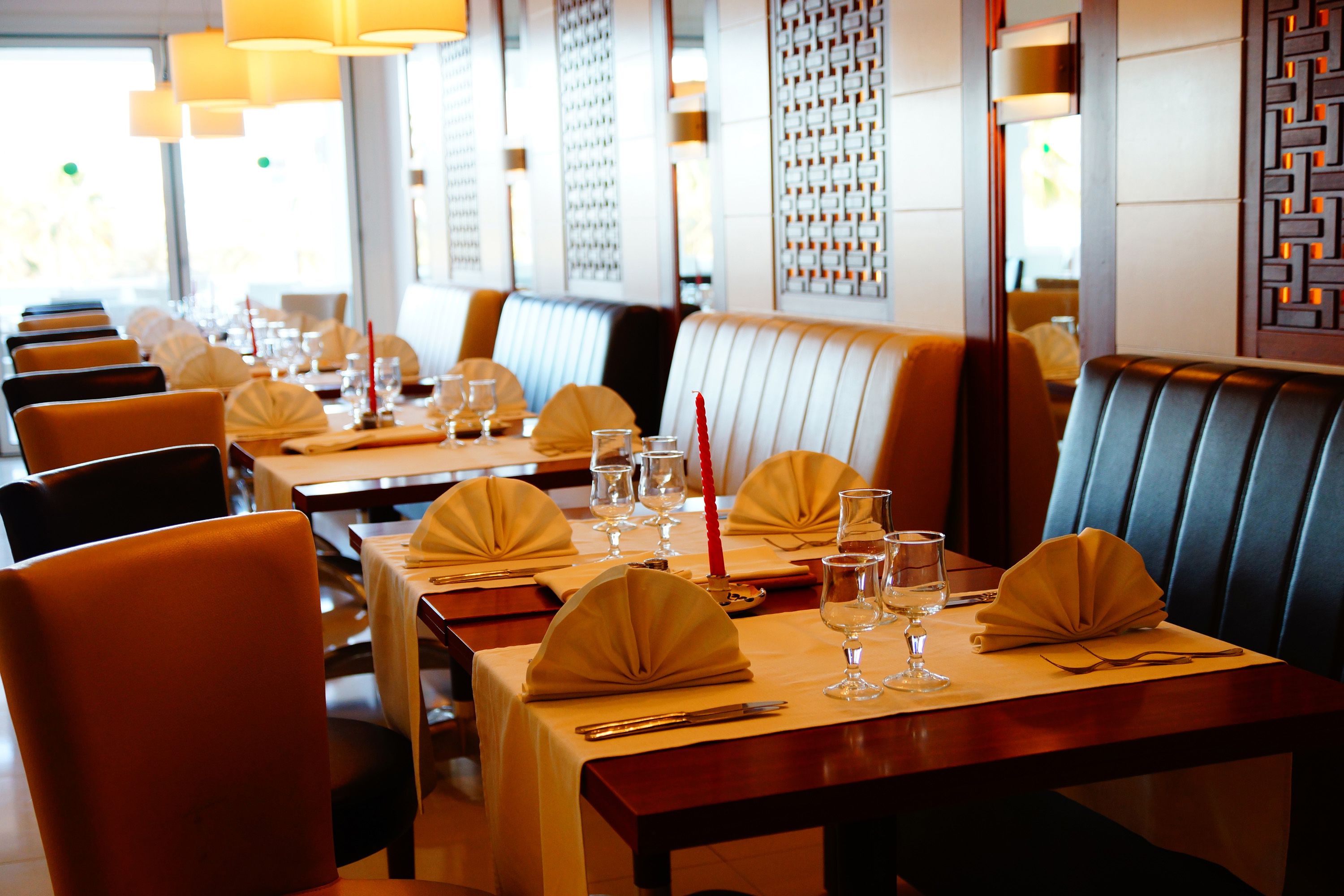 A restaurant with booths and tables set for dining.