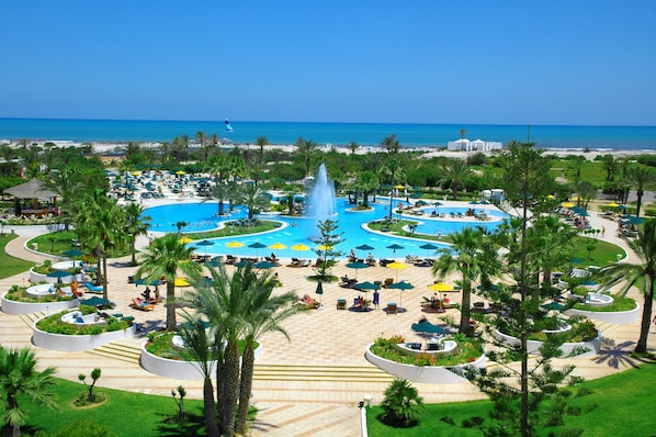 Piscine couverte, piscine extérieure, parasols de plage, chaises longues