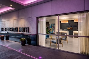 El exterior del Hotel Bethesda, con una fachada moderna, ventanas amplias y una zona de recepción visible en el interior.