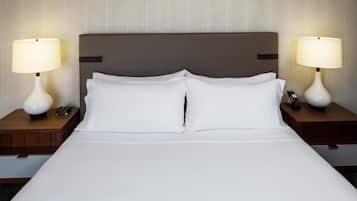Une chambre d’hôtel avec un grand lit, deux tables de chevet avec des lampes et une tête de lit.