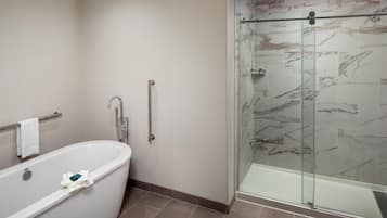 A bathroom with a freestanding bathtub, a glass shower enclosure, and a towel rack.
