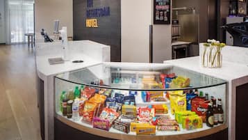 Zona de recepción de un hotel con una vitrina de aperitivos y bebidas.